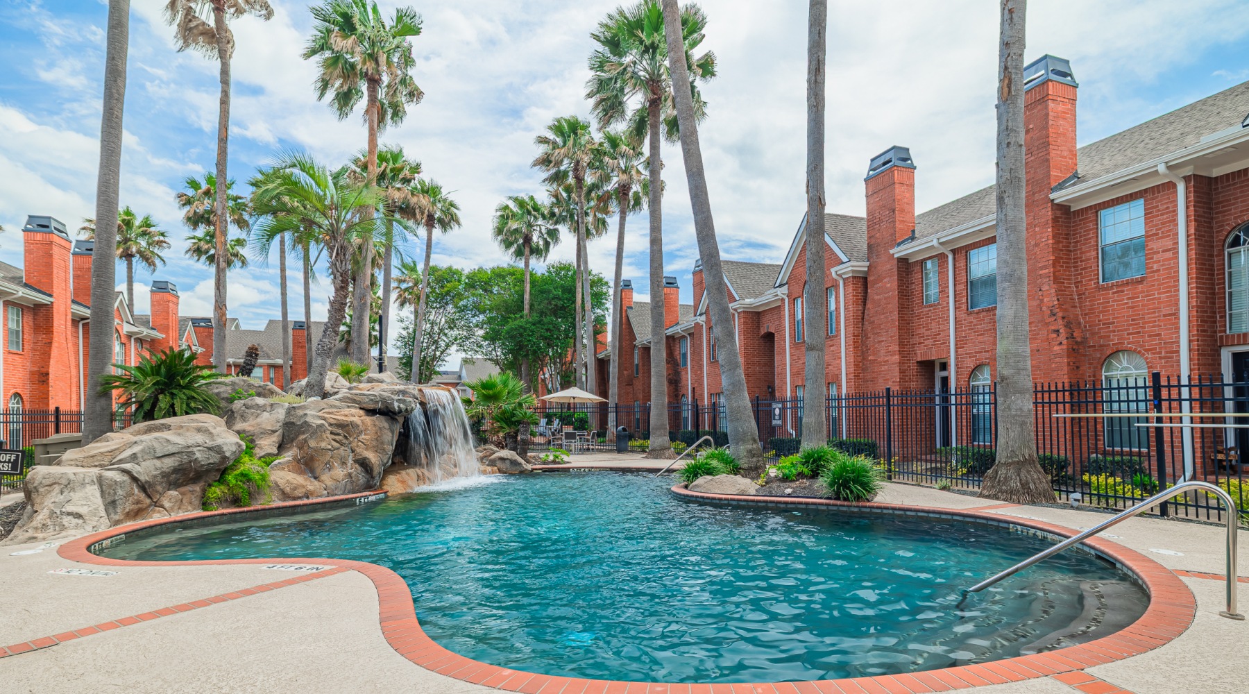swimming pool with palm trees and water feature
