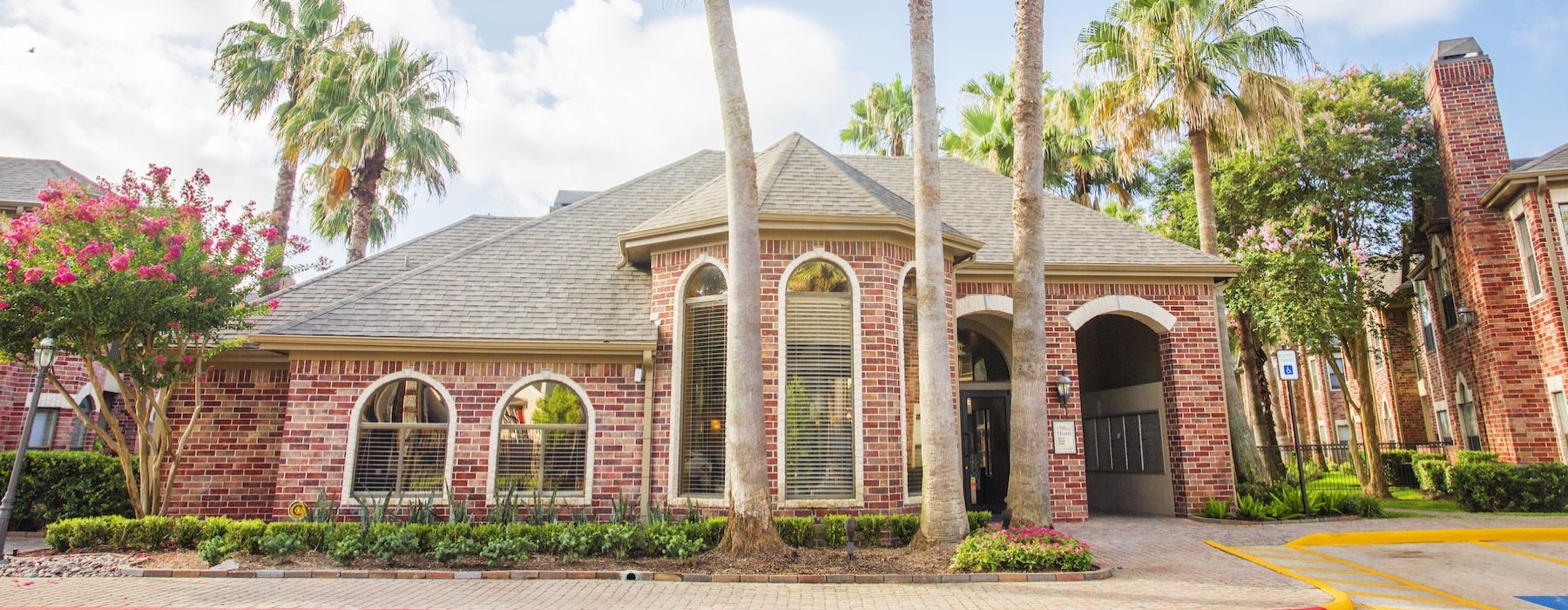 the front of a building with palm trees