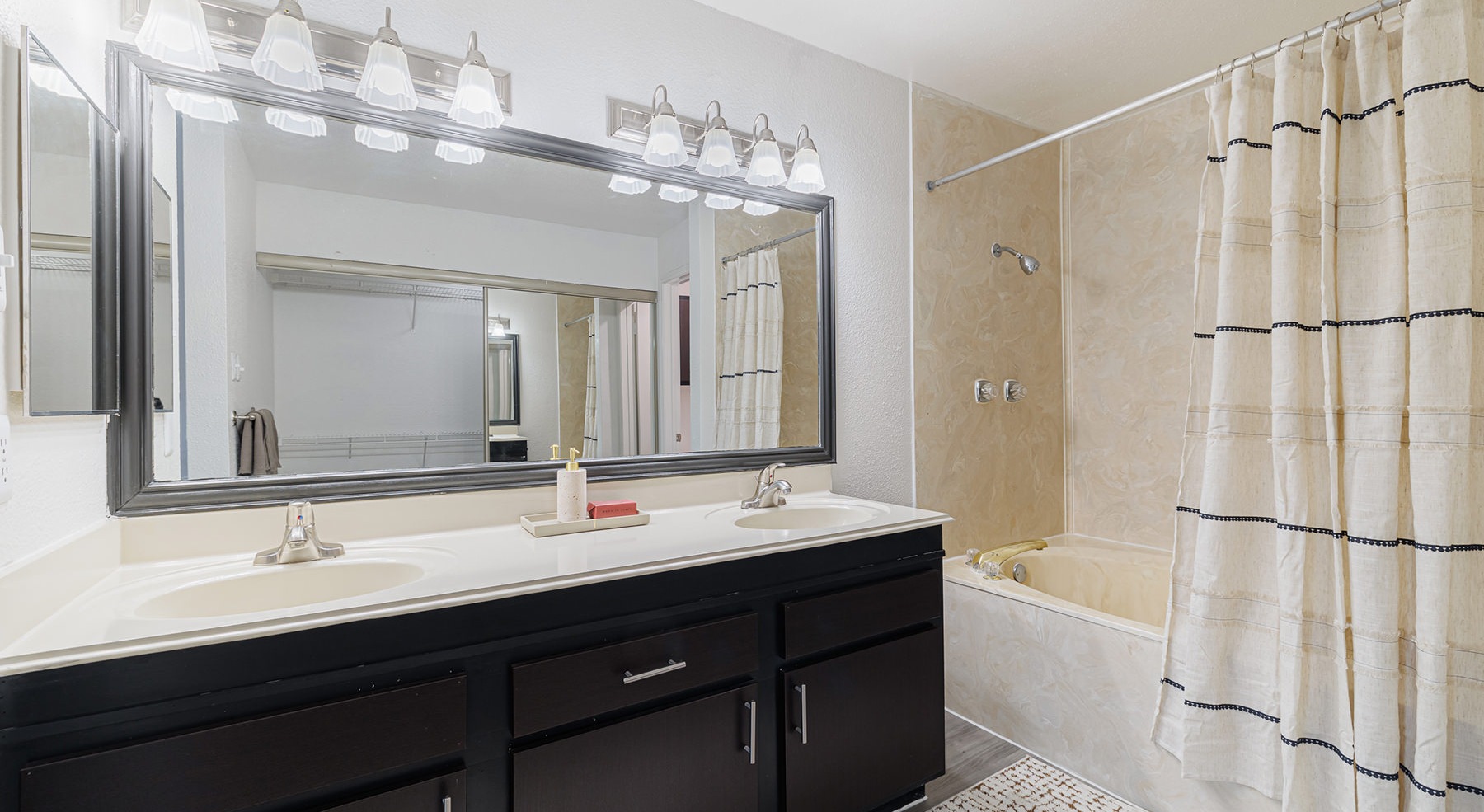 bathroom with large mirror shower and sinks