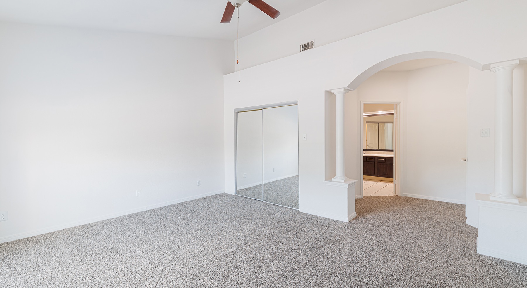 bedroom with carpet ceiling fan mirrors