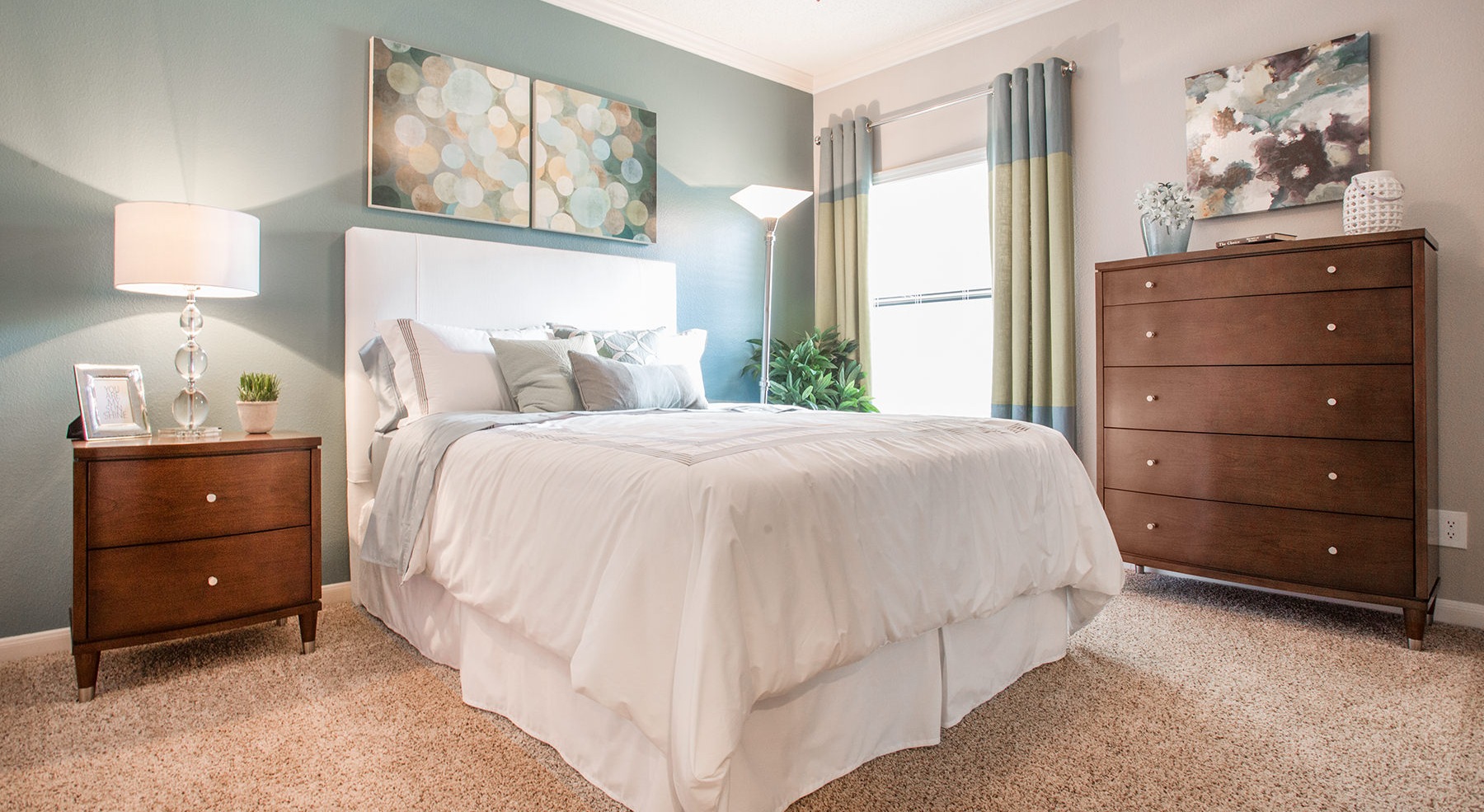 bedroom with bed lamp window and art above bed