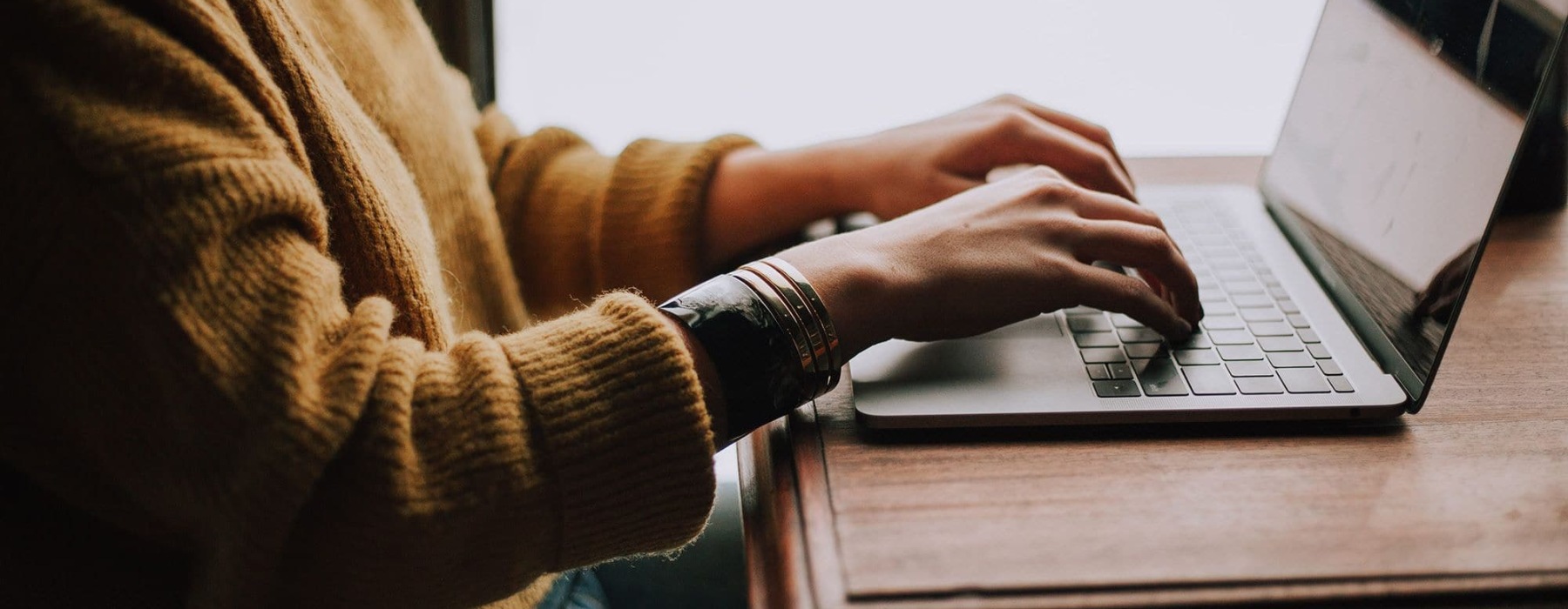 hands typing on a laptop